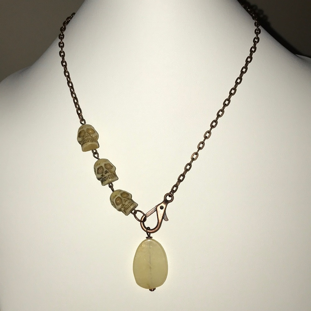 Handmade copper necklace with skull bead detail.
